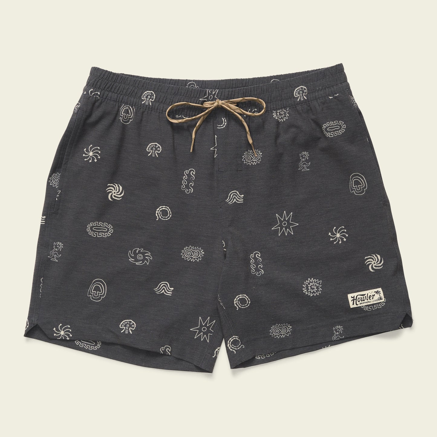 Dark gray boardshorts featuring a 7” inseam, tan drawstring, and small white abstract patterns throughout. An elastic waistband ensures comfort, while a rectangular patch with “Howler” is sewn near the lower left hem. - View 1