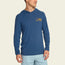 A man wearing a blue lightweight hoodie with a small yellow Howler logo and graphic on the left chest, paired with light blue shorts, stands against a plain off-white background.