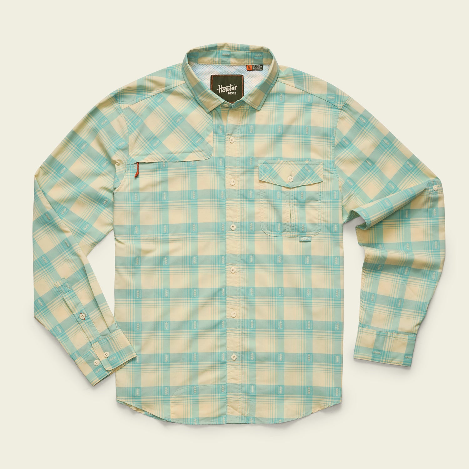 A long-sleeve, button-up Matagorda Shirt in light blue and cream plaid, featuring two chest pockets and a collar, laid flat on a beige background—perfect as a quick drying travel shirt for any adventure.
