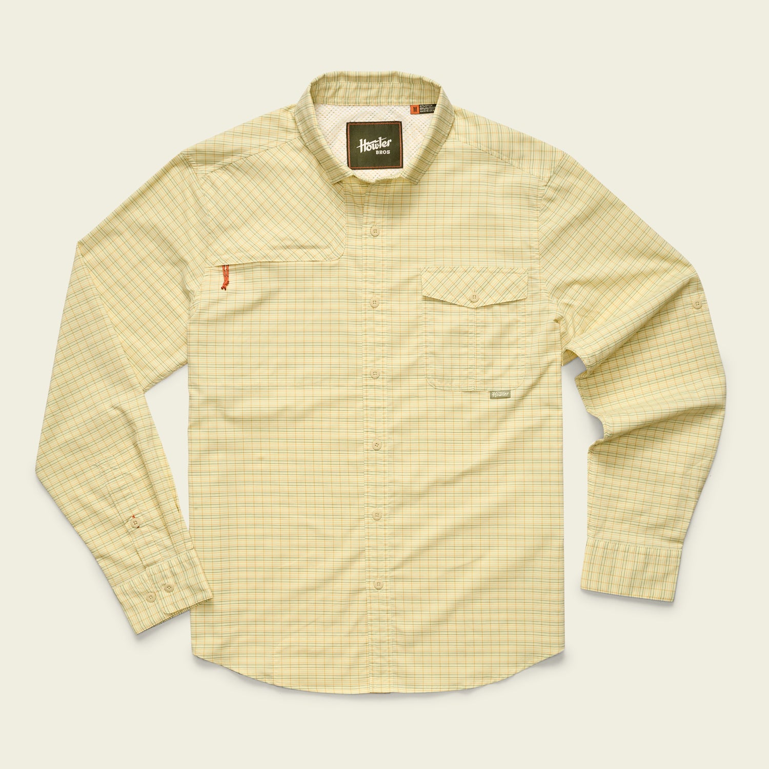 A long-sleeve, light yellow Matagorda Shirt with a subtle plaid pattern, collar, and chest pocket. Quick drying and perfect as a travel shirt, it’s laid flat on a light background.