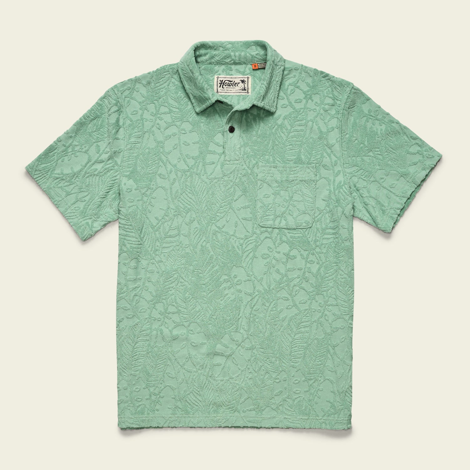 A light green soft polo with short sleeves and a subtle textured leaf pattern, featuring a single chest pocket and buttoned collar, displayed flat on a cream background.